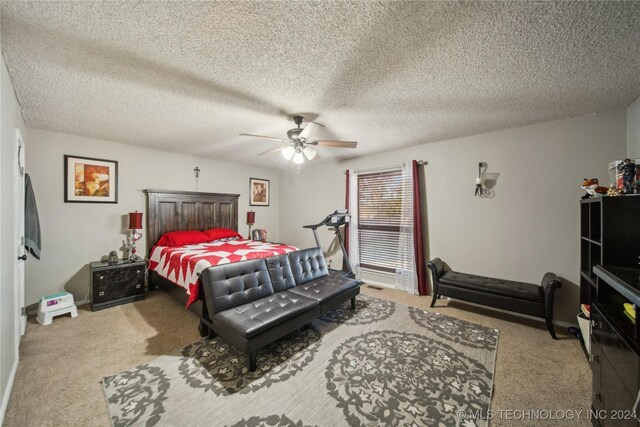 carpeted bedroom featuring ceiling fan and a textured ceiling