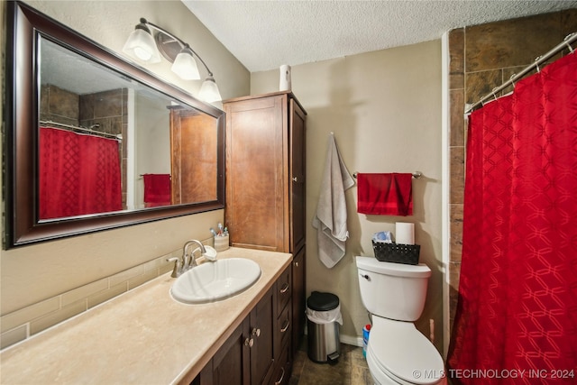 bathroom with a shower with curtain, vanity, toilet, and a textured ceiling