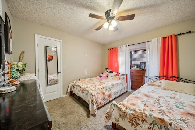 carpeted bedroom with ceiling fan and a textured ceiling