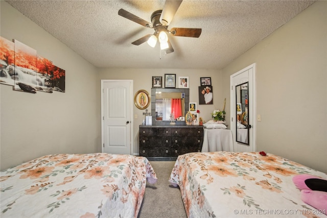 carpeted bedroom featuring ceiling fan and a textured ceiling