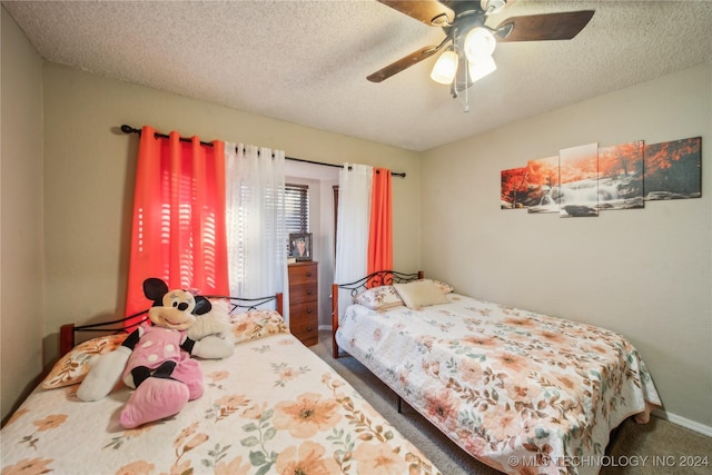 carpeted bedroom featuring ceiling fan and a textured ceiling