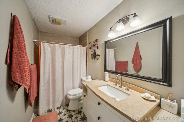 bathroom with a shower with shower curtain, tile patterned floors, vanity, a textured ceiling, and toilet