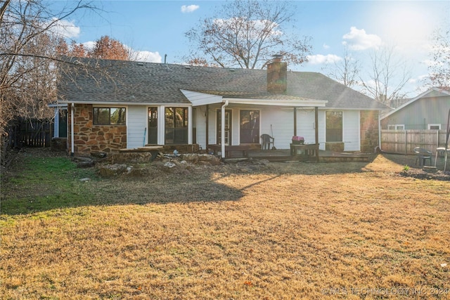 back of property featuring covered porch and a yard