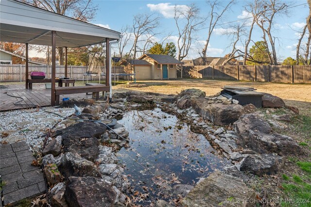 view of yard with a storage shed, a trampoline, and a wooden deck