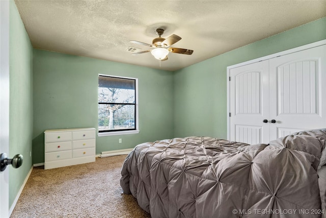 carpeted bedroom with ceiling fan, a textured ceiling, and a closet