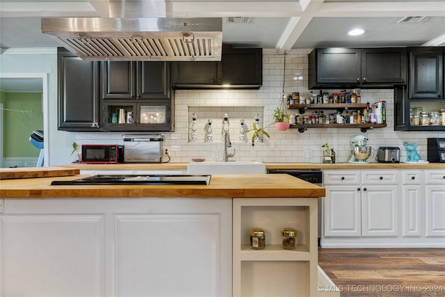 kitchen featuring stainless steel gas stovetop, decorative backsplash, exhaust hood, and wooden counters