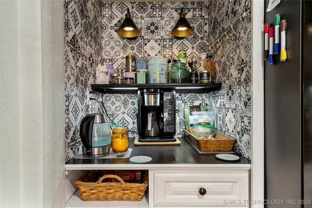 bar with stainless steel refrigerator, decorative backsplash, and white cabinets