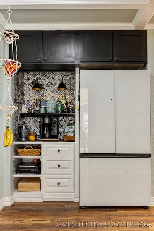 bar with tasteful backsplash, crown molding, white refrigerator, white cabinets, and hardwood / wood-style floors