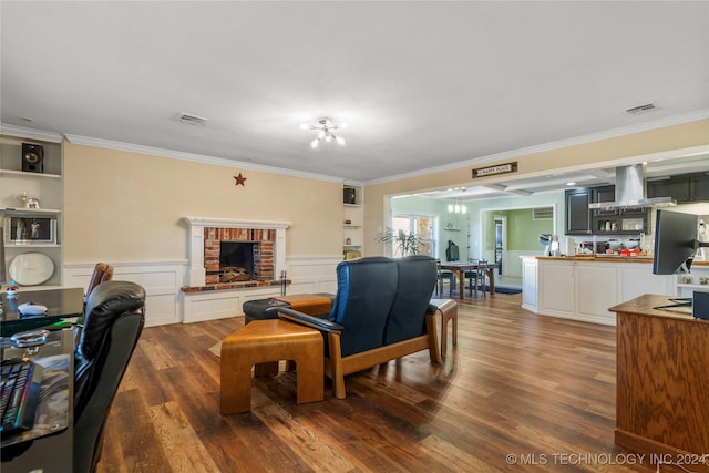 living room with built in shelves, crown molding, dark wood-type flooring, and a brick fireplace