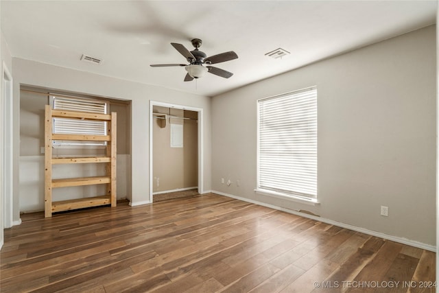 unfurnished bedroom featuring ceiling fan, dark hardwood / wood-style flooring, and a closet