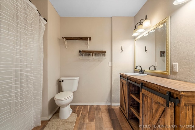 bathroom with hardwood / wood-style floors, vanity, and toilet