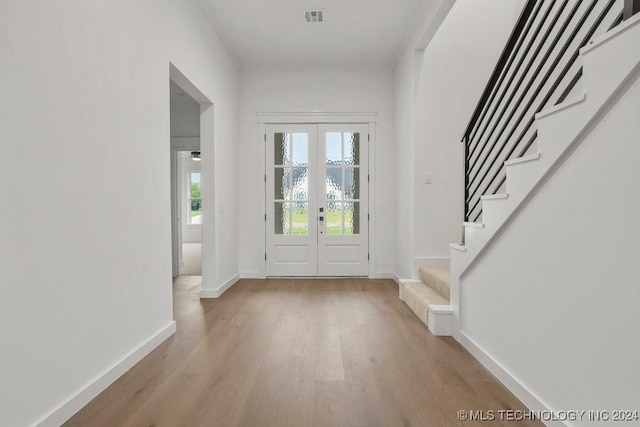 entryway with french doors and light hardwood / wood-style flooring