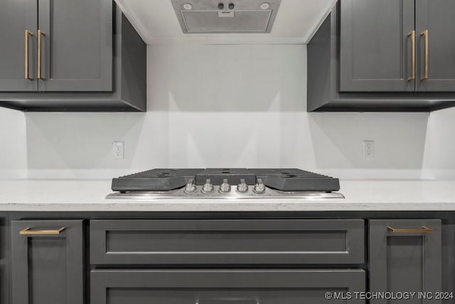 kitchen featuring gray cabinets, stainless steel gas cooktop, and range hood