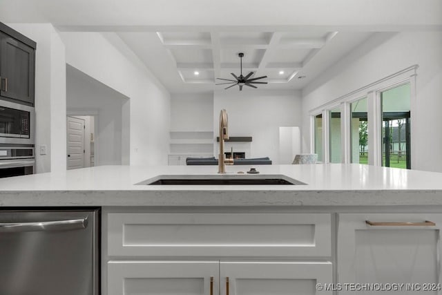 kitchen featuring sink, ceiling fan, light stone counters, white cabinetry, and stainless steel appliances