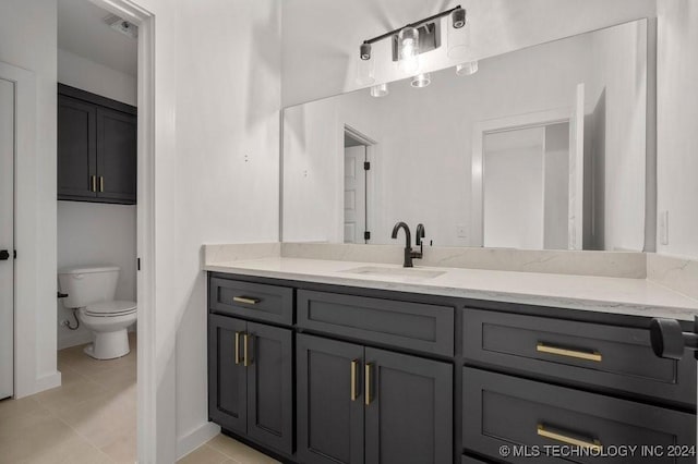 bathroom featuring tile patterned floors, vanity, and toilet