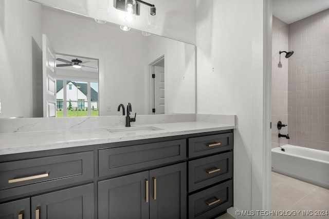 bathroom featuring tile patterned flooring, ceiling fan, vanity, and tiled shower / bath combo