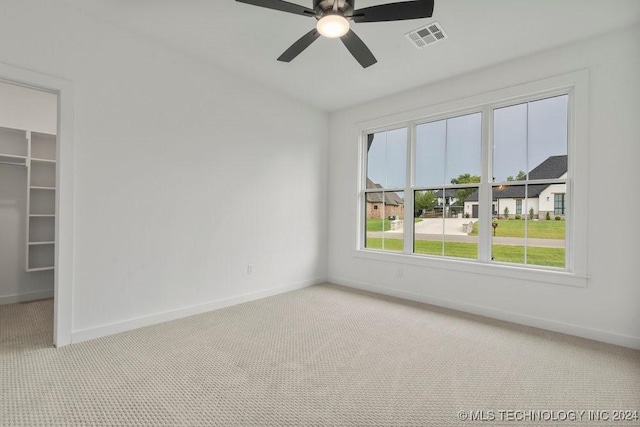 carpeted empty room featuring ceiling fan