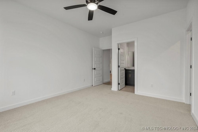 unfurnished bedroom featuring ensuite bathroom, ceiling fan, and light colored carpet