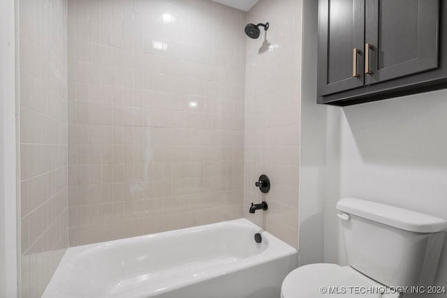 bathroom featuring toilet and tiled shower / bath