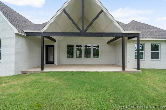 rear view of house with a yard and a patio