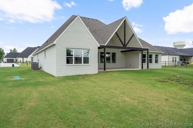 back of house with a lawn, central AC unit, and a patio area