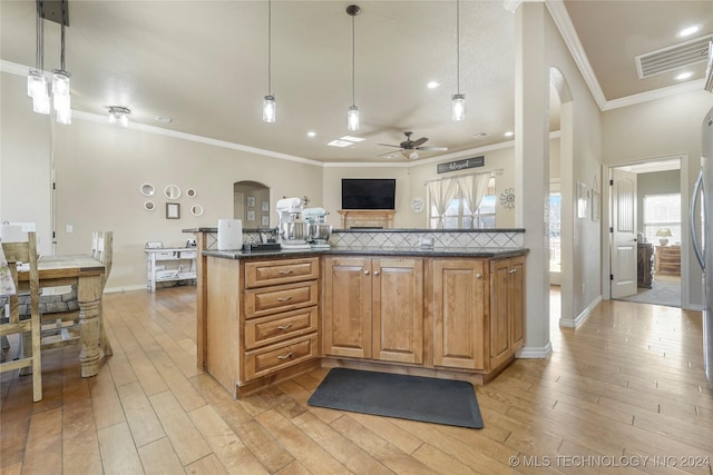 kitchen with decorative light fixtures, light hardwood / wood-style floors, ornamental molding, and ceiling fan