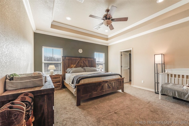 bedroom featuring ceiling fan, light colored carpet, a tray ceiling, and multiple windows