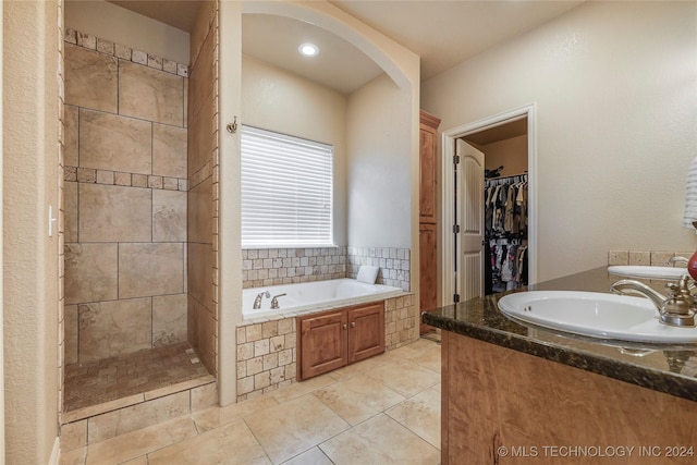 bathroom with tile patterned floors, sink, and plus walk in shower