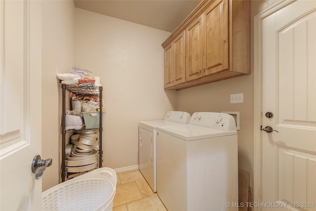 clothes washing area featuring cabinets, separate washer and dryer, and light tile patterned floors