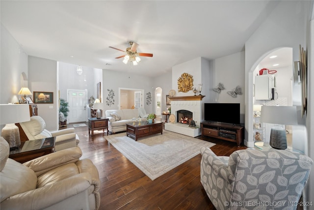 living room with ceiling fan and dark hardwood / wood-style flooring