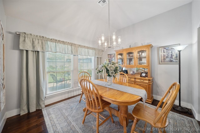 dining room with dark hardwood / wood-style floors, lofted ceiling, and a chandelier