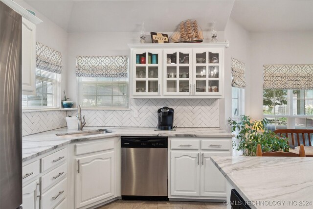 kitchen featuring dishwasher, white cabinets, and plenty of natural light