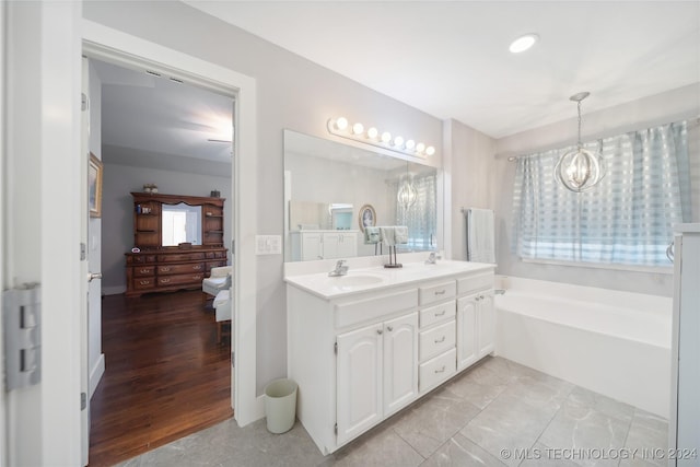 bathroom with a washtub, hardwood / wood-style floors, vanity, and a wealth of natural light