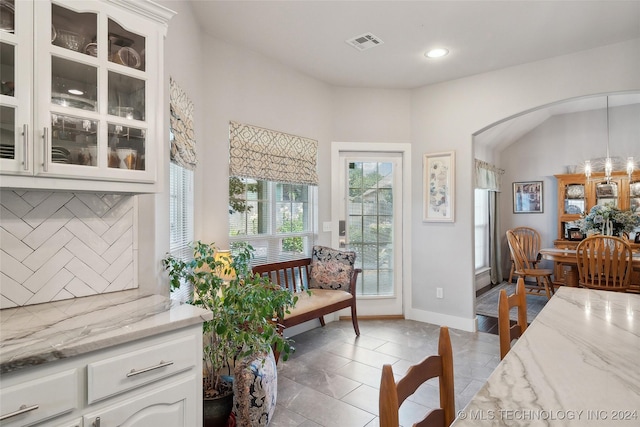 interior space featuring vaulted ceiling and light tile patterned flooring