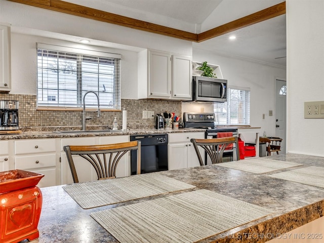 kitchen featuring tasteful backsplash, sink, white cabinets, and appliances with stainless steel finishes