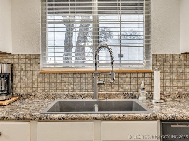 kitchen featuring white cabinets, dishwasher, and sink