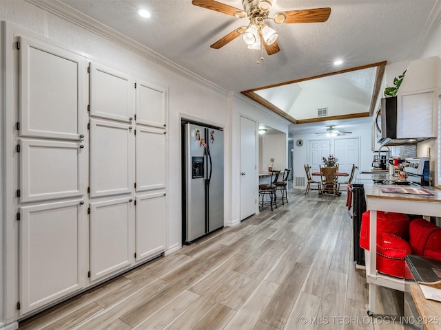 kitchen with white cabinetry, stainless steel fridge with ice dispenser, a textured ceiling, and ornamental molding