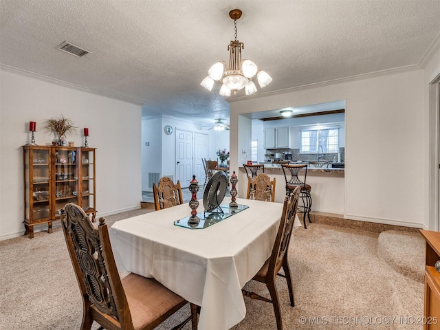 dining room featuring crown molding, ceiling fan with notable chandelier, light colored carpet, and a textured ceiling