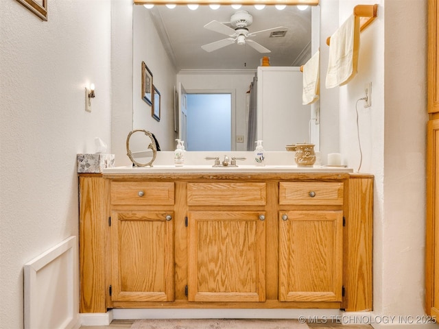 bathroom with ceiling fan, crown molding, and vanity