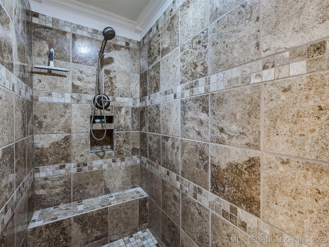 interior space featuring a tile shower and crown molding