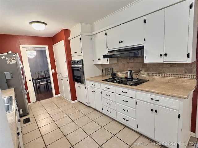 kitchen featuring tasteful backsplash, sink, black appliances, light tile patterned floors, and white cabinets