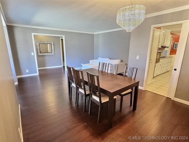 dining space with dark hardwood / wood-style floors, crown molding, and an inviting chandelier