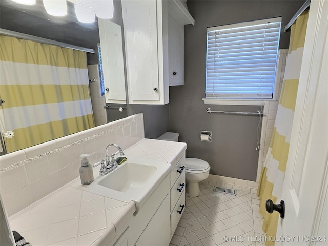 bathroom featuring tile patterned flooring, decorative backsplash, vanity, and toilet