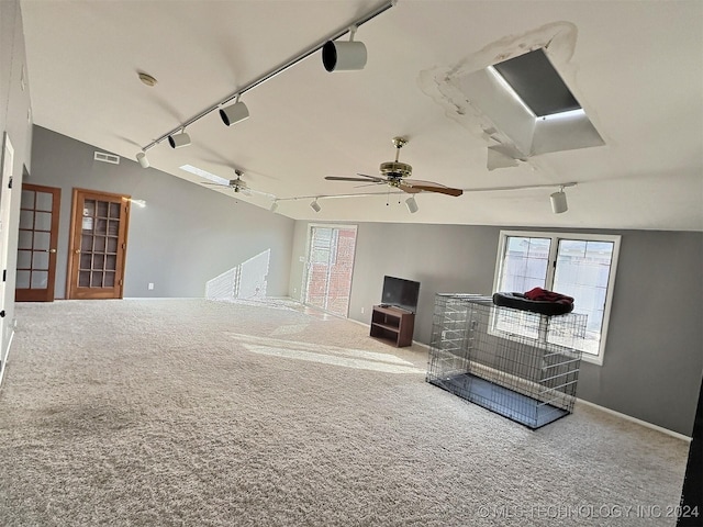 interior space featuring carpet, vaulted ceiling, and track lighting