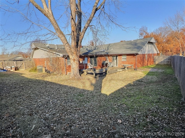 back of house with central AC and a yard