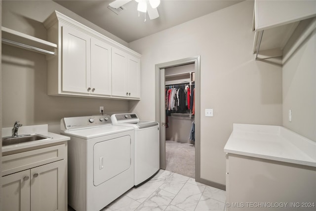 laundry area featuring sink, cabinets, light colored carpet, ceiling fan, and washing machine and dryer