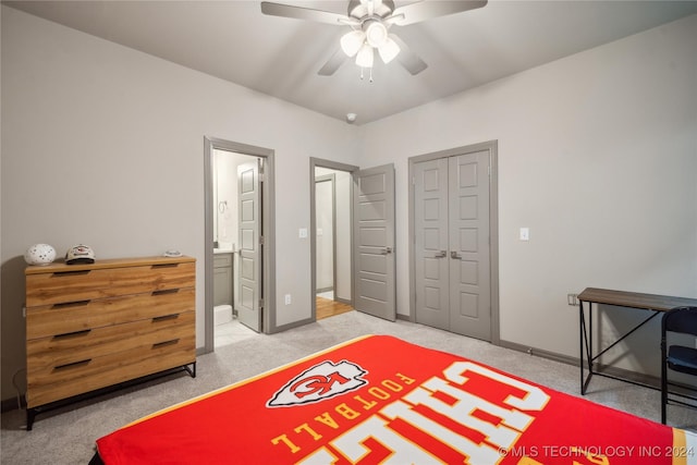 carpeted bedroom featuring ceiling fan, ensuite bath, and a closet