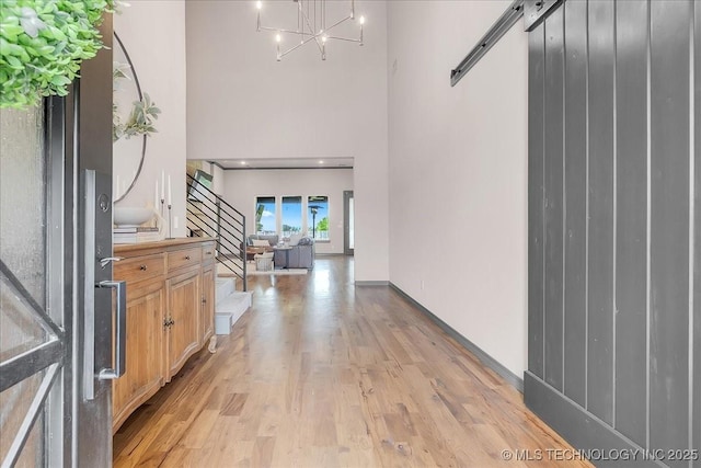 4255 S 173rd E Ave, Tulsa, OK 74134 - entryway featuring a towering ceiling, light wood-style floors, a chandelier, stairway, and a barn door