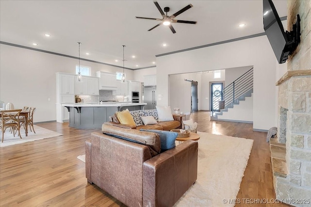 4255 S 173rd E Ave, Tulsa, OK 74134 - living room featuring ceiling fan, light wood-style floors, stairs, crown molding, and recessed lighting