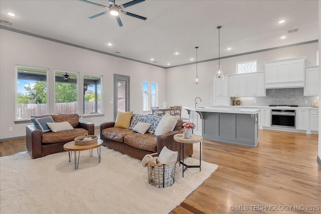 4255 S 173rd E Ave, Tulsa, OK 74134 - living room with a ceiling fan, light wood-style flooring, ornamental molding, and recessed lighting